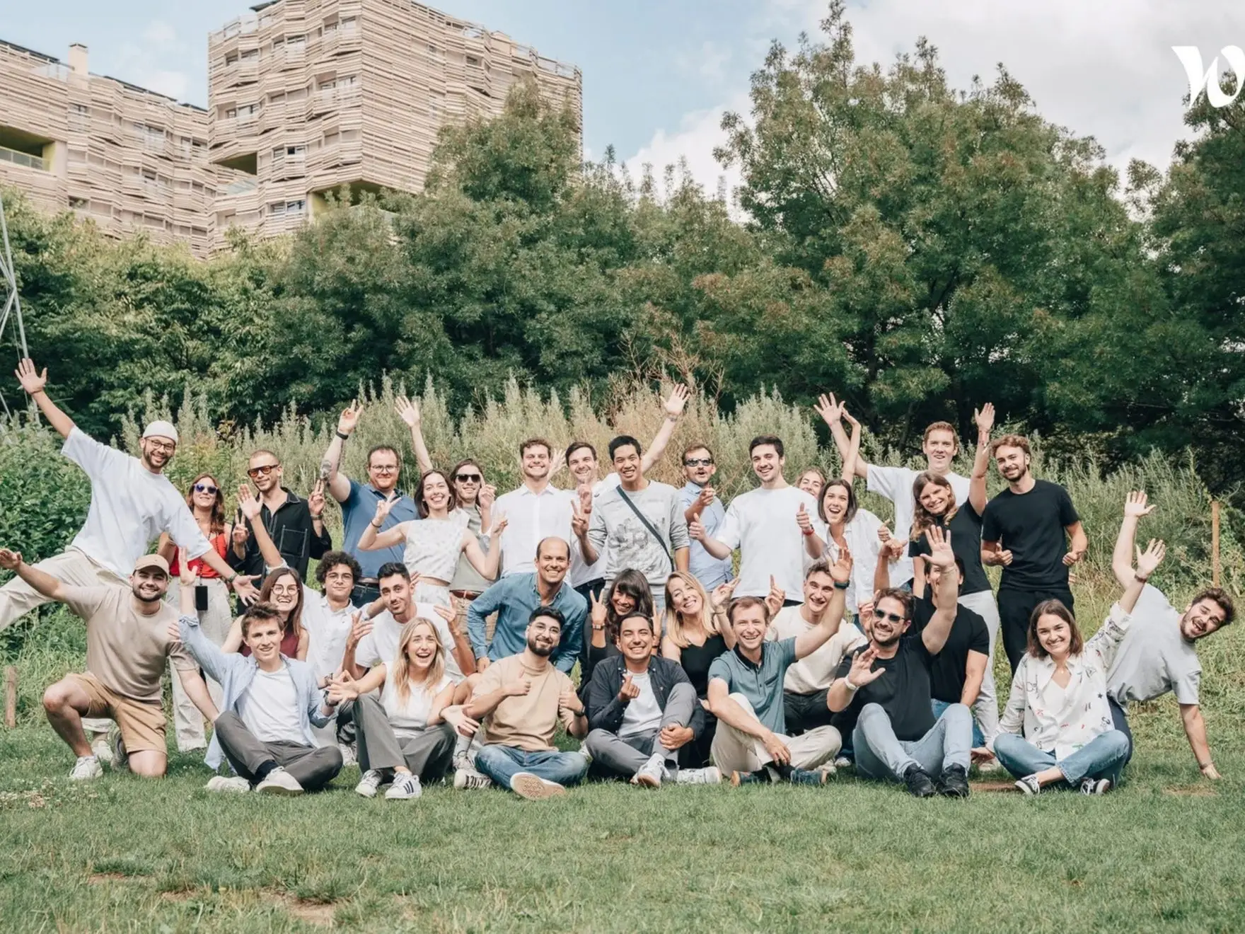 L'équipe Dipli réunie sur une pelouse, souriante, bras levés